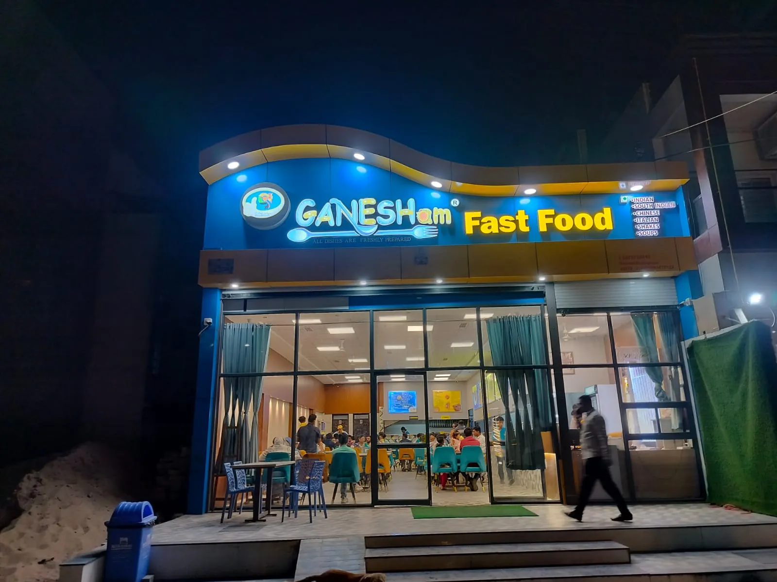 Ganesham, a pure veg restaurant in Ujjain — illuminated storefront on Sanwer Road, Nanakheda at night
